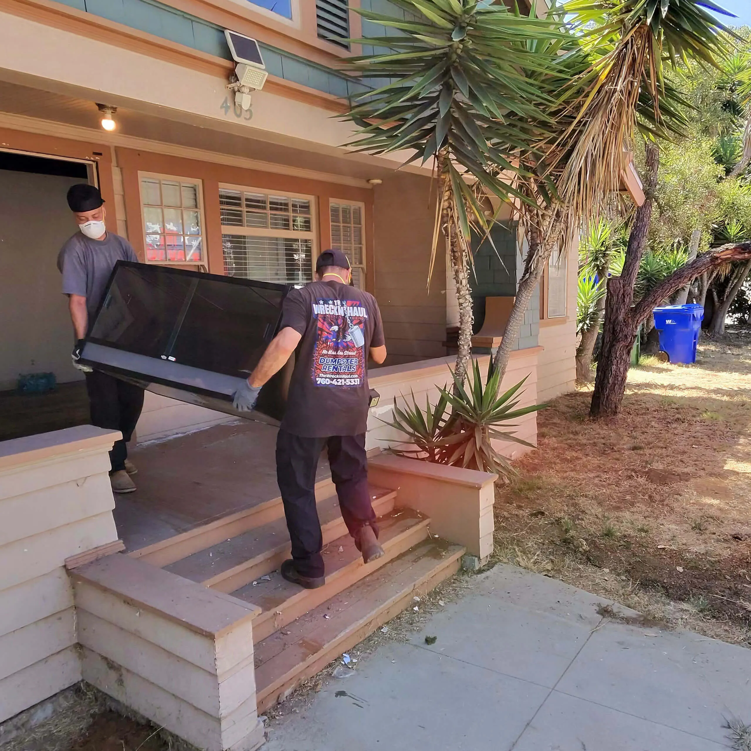 In-home junk removal crew lifting and hauling items out